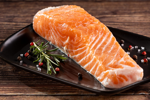 Fresh raw salmon fillet on plate.