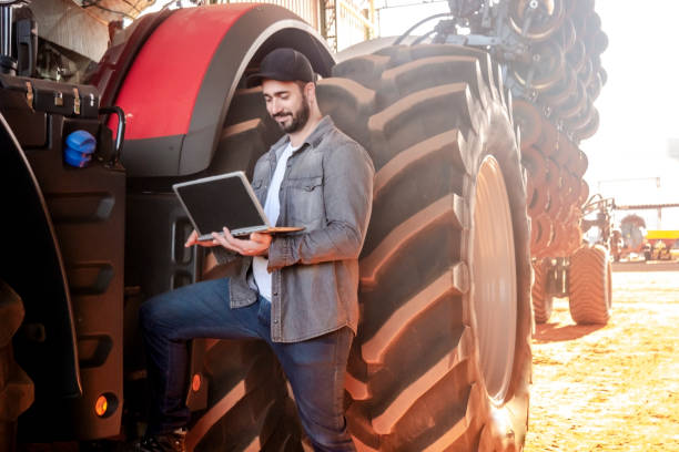 istock Man beside a big farm tractor 1512226049