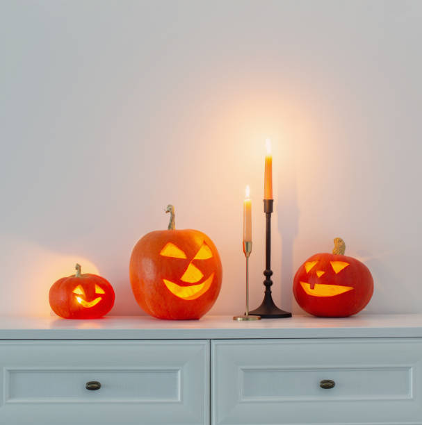 istock halloween pumpkins with burning candles in white interior 1512399501