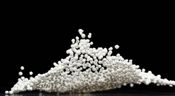 Sago seeds falling down from measure cup, white grain wave floating, Abstract fly splash in air. White Sago seeds is material food. Black background isolated selective focus blur
