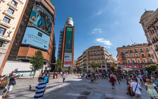 Madrid, Spain - June 22, 2023: Ordinary people and tourists stroll along Plaza de Callao next to Gran Via, in Madrid on a hot summer day. The Plaza del Callao was built between 1917 and 1922. Currently, 113 million people pass through it annually.