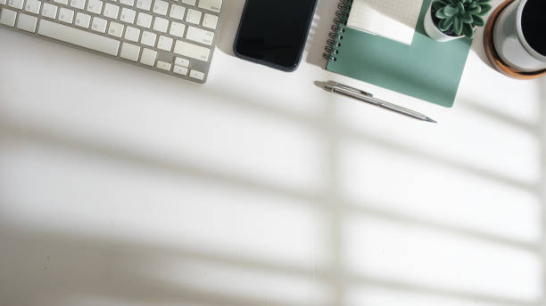 istock Top view of white office desk with smart phone, notebook, coffee cup and keyboard. Copy space for your text. 1512510190