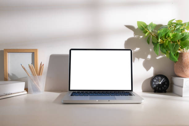 istock Laptop computer with empty display, notepad, coffee cup, stationery and houseplant on white table. 1512511220