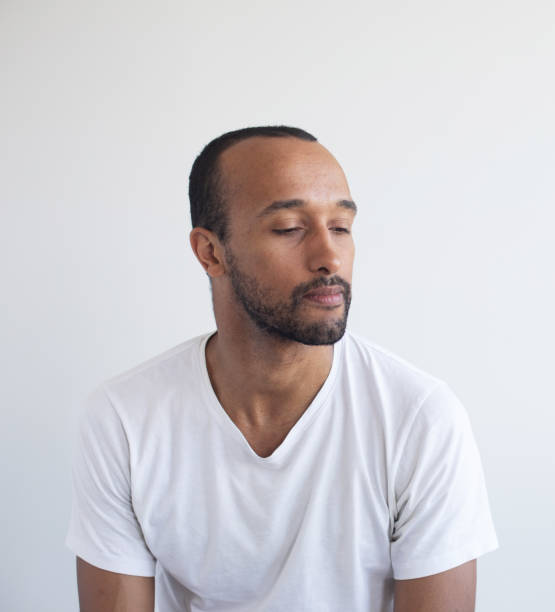 istock A young unshaven man on a light gray background. 1512520504