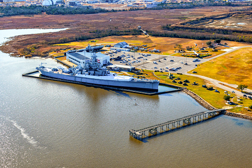 Mobile, United States - January 31, 2022:  Aerial view of the U.S.S. Alabama Battleship Memorial Park from above including the U.S.S. Alabama and the skyline of downtown Mobile, Alabama in the background.