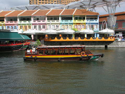 January 3, 2009 - Singapore city, Singapore.\nColourful historic houses at Clarke Quay on Singapore River in Singapore city with bumboats and tour boats in the river. Many of these colourful shop houses have been converted in popular restaurants.