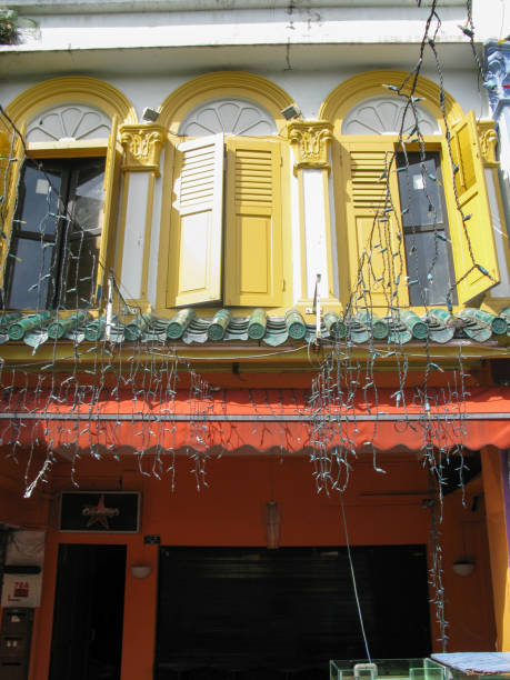 finestre ad arco con persiane in legno louvred al secondo piano di un vecchio edificio coloniale a boat quay, singapore. di solito ci sono ristoranti o bar al piano terra. - louvred foto e immagini stock