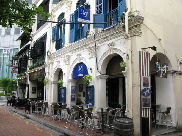 restaurants and pubs at boat quay on singapore river in downtown singapore city. this is the original harry's boat quay in an old shop house building with black louvred windows and doors, a famous pub and restaurant in singapore. - louvred imagens e fotografias de stock