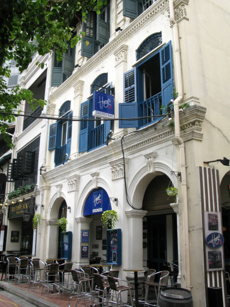 restaurants and pubs at boat quay on singapore river in downtown singapore city. this is the original harry's boat quay in an old shop house building with blue louvred windows and doors, a famous pub and restaurant in singapore. - louvred imagens e fotografias de stock