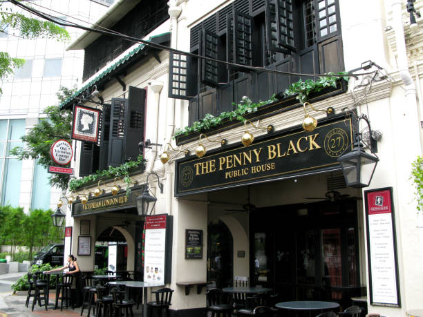 restaurants and pubs at boat quay on the bank of the singapore river in downtown singapore city. this is the penny black public house in an old shop house building with black louvred windows and doors, a famous pub in singapore. - louvred imagens e fotografias de stock