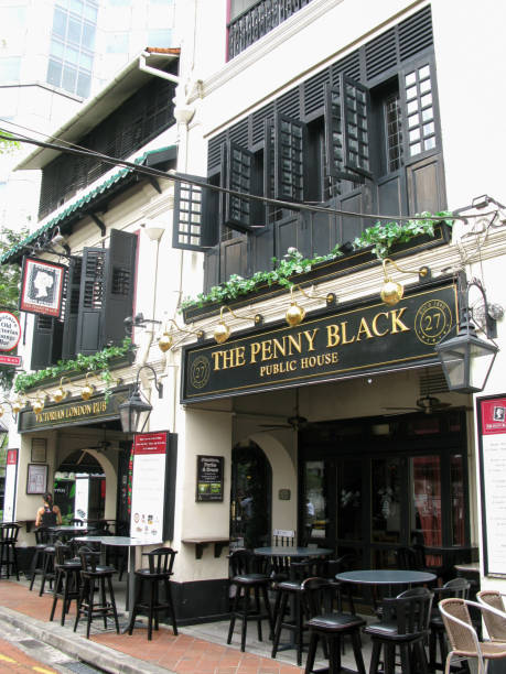restaurants and pubs at boat quay on the bank of the singapore river in downtown singapore city. this is the penny black public house in an old shop house building with black louvred windows and doors, a famous pub in singapore. - louvred imagens e fotografias de stock