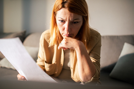 Close up of a Young woman going over her finances at home while using her laptop