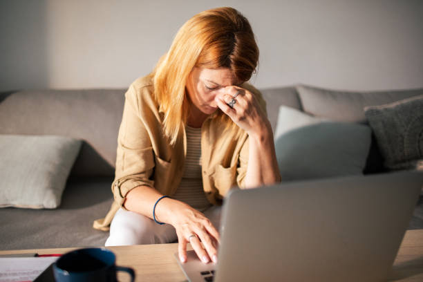istock Young woman going over her finances at home while using her laptop 1512580518