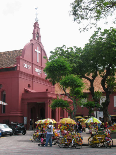 the christ church melaka in downtown melaka or malacca. the church is an 18th century dutch built anglican church in a bright red colour as were many of the dutch buildings during this period. it is a popular tourist destination in malaysia. - cyclo cross imagens e fotografias de stock