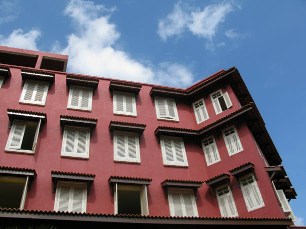 January 8, 2009 - Melaka, Malacca State, Malaysia.\nAn old red walled colonial building with white window shutters in Red Square in downtown Melaka City, Malacca State, Malaysia.
