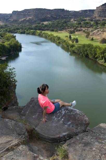 istock Woman sits on rock overlooking Snake River. 1512666475