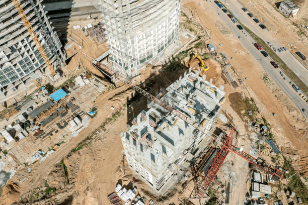 istock busy construction site. cranes and high-rise apartment buildings under construction. aerial view from above in sunny day. 1512869934