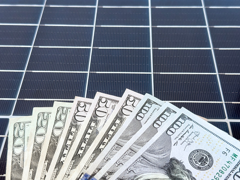 100 dollar bills on a solar cell panel