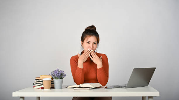 istock Young adorable college student sitting at her study desk, white isolated background. 1512884753