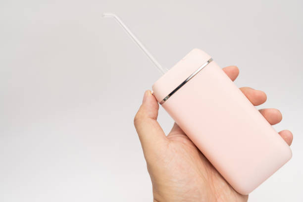 Oral Irrigator Pink Oral Irrigator, Electric Interdental Cleaner. Dental water shower isolated on white. portable water jet teeth cleaner. deep pick stock pictures, royalty-free photos & images