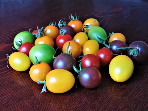 Tomato and parsley on dark concrete background. Selective focus