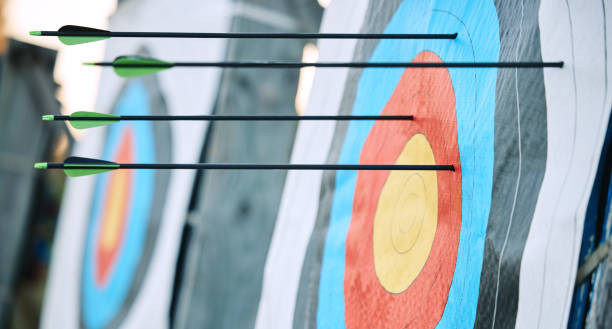 istock Arrows in archery target or circle for competition, game or learning in field outdoor for sports background. Sport event, icon or eye goal with arrow on board for gaming, adventure and shooting 1512944606