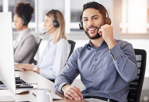 Portrait, call center and customer service with a man consulting using a headset in his support office. CRM, contact us or telemarketing with a male consultant working  in an agency for communication
