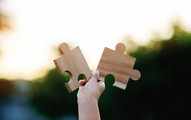 istock Jigsaw in hand, a puzzle piece that is critical to success. Creativity, ideas, initiative, unity, teamwork 1512948333
