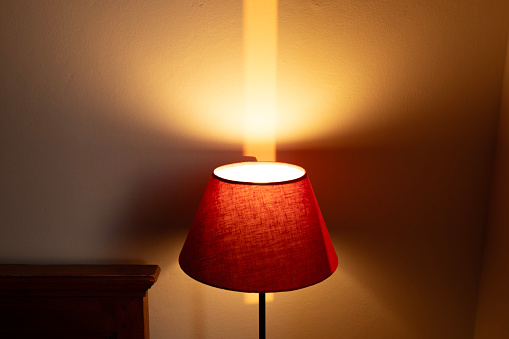 Light on the wall of a red table lamp.
