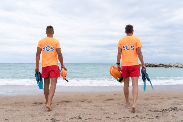 istock Lifeguards walking with a float on a beach watch 1513111841