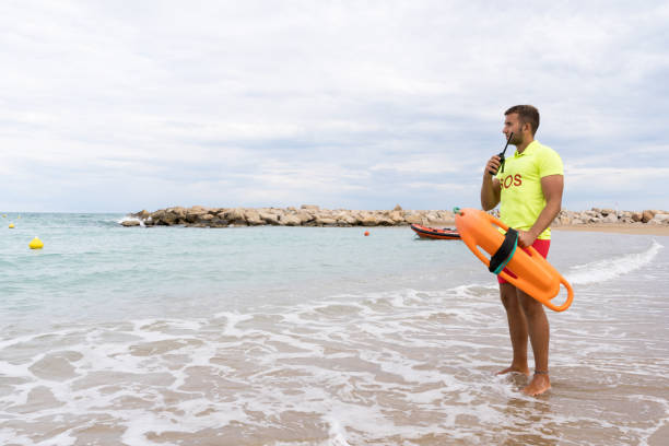 istock Lifeguard standing on the sea water using a radio 1513112390