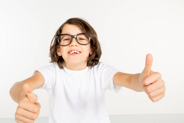 Portrait of a young boy. 10 year old boy make face on white background. White t-shirt and red sweatpants. white people.