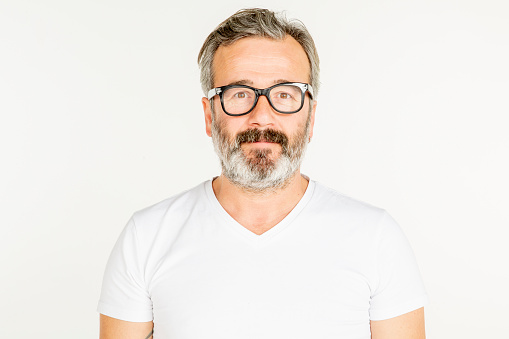 Portrait of a real man with glasses and beard. Various facial expressions. In front of a white background. Studio shoot. White people.