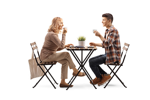 Mother and son at a cafe enjoying a cup of coffee isolated on white background