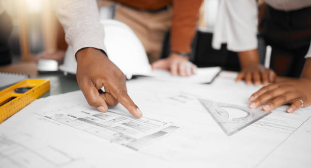 istock Hands, collaboration and design with a building team working in their office on architecture from above. Teamwork, construction or blueprint with an architect, designer and engineer at work together 1513191930