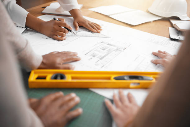istock Hands, collaboration and design with a architecture team working in their office for planning from above. Teamwork, construction or blueprint with an architect, designer and engineer at work together 1513191931