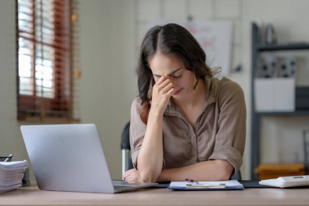 istock Asian business woman feeling stress at work when faced with difficult and hard work Feeling headaches and eye strain and working on a laptop computer in the office. 1513212154