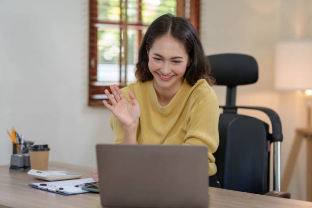 istock Beautiful young Asian woman college student is video chatting with her classmates using laptop, smiling faces and gestures happily studying. 1513212686