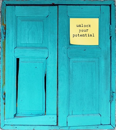 Blue vintage wood window text in sticky note UNLOCK YOUR POTENTIAL ,concept of to unfold talents, when someone capable to do more, think less and act more, start to put dreams in practicality.