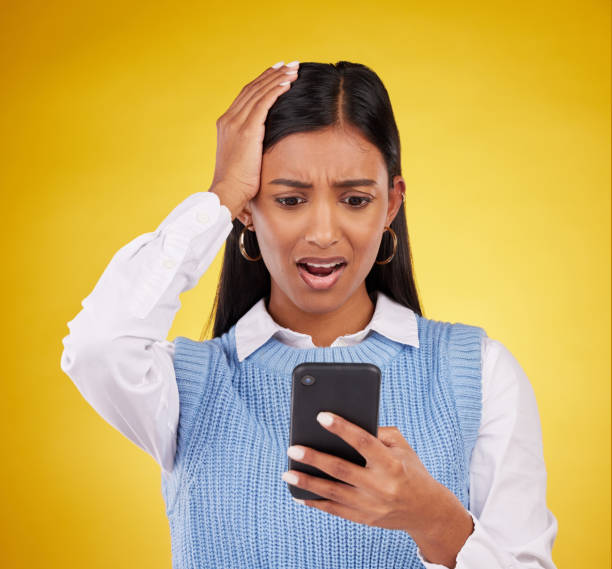 istock Problem, bad news and a woman with a notification on a phone isolated on a studio background. Sad, glitch and an indian girl reading a message on a mobile app with shock and surprise on a backdrop 1513238420