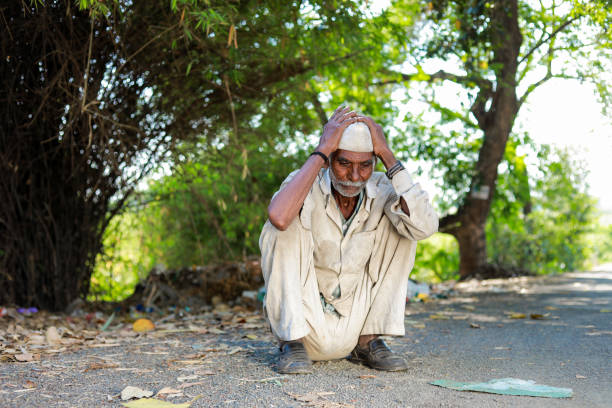 Maharashtra , India - April 2023 Indian old farmer, loss in farm , Old Indian men sitting tired, hungry old man