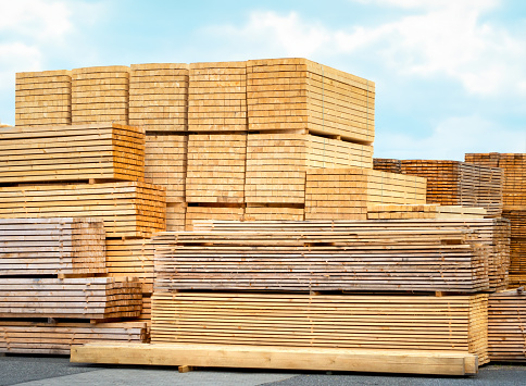 Stack of sawed tree trunks in panoramic close-up - wood industry background