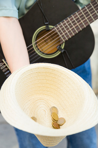 Street Musician's Hat with a Generous Donation of Coins, Symbolizing Support and Solidarity