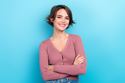 Photo of cheerful positive lady wear pink cardigan smiling arms crossed isolated blue color background.