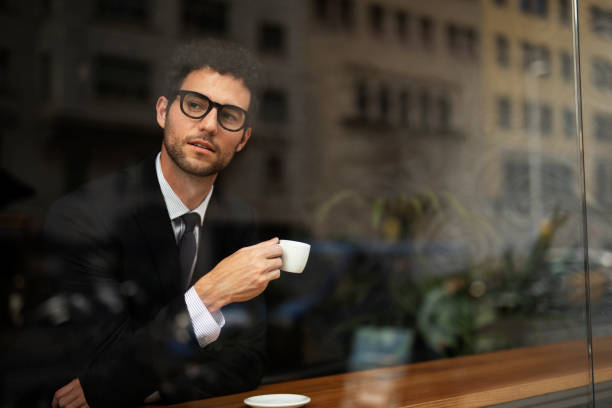 istock Young man in suit drinking coffee in cafe 1513269307