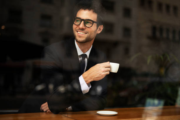 istock Young man in suit drinking coffee in cafe 1513269845
