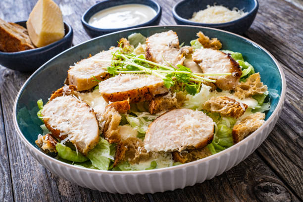 istock Caesar salad  - vegetable salad with roast chicken breast on wooden table 1513292377
