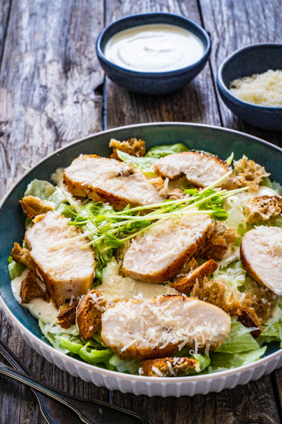 istock Caesar salad  - vegetable salad with roast chicken breast on wooden table 1513292420