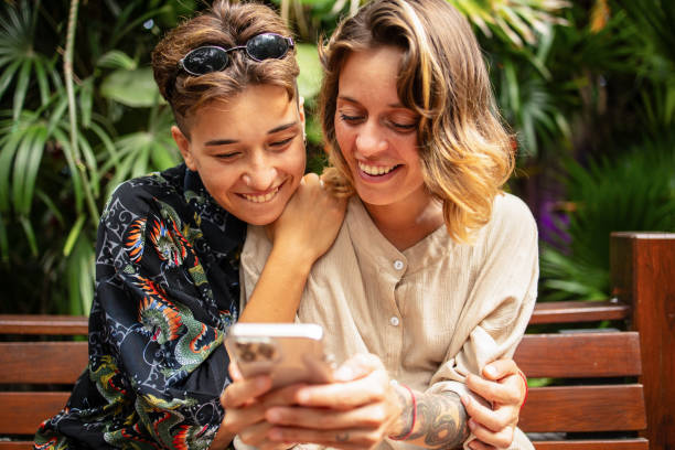 istock Same sex couple using mobile phone in the city 1513303879