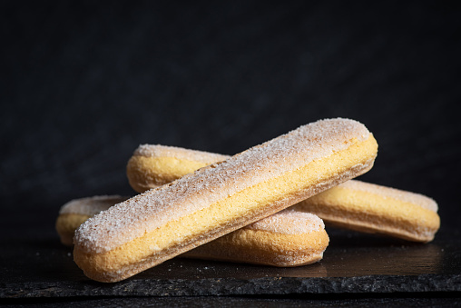 Italian sponges fingers. Italian savoiardi cookies. Ladyfinger cookies o black background